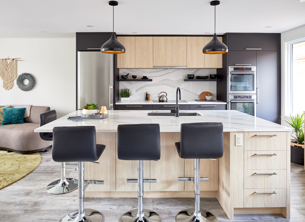 This is an example of a mid-sized contemporary single-wall eat-in kitchen in Toronto with a triple-bowl sink, flat-panel cabinets, black cabinets, quartz benchtops, white splashback, stainless steel appliances, medium hardwood floors, with island, grey floor and white benchtop.