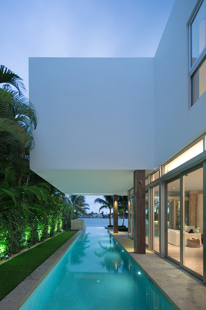 Photo of a tropical side yard lap pool in Miami.