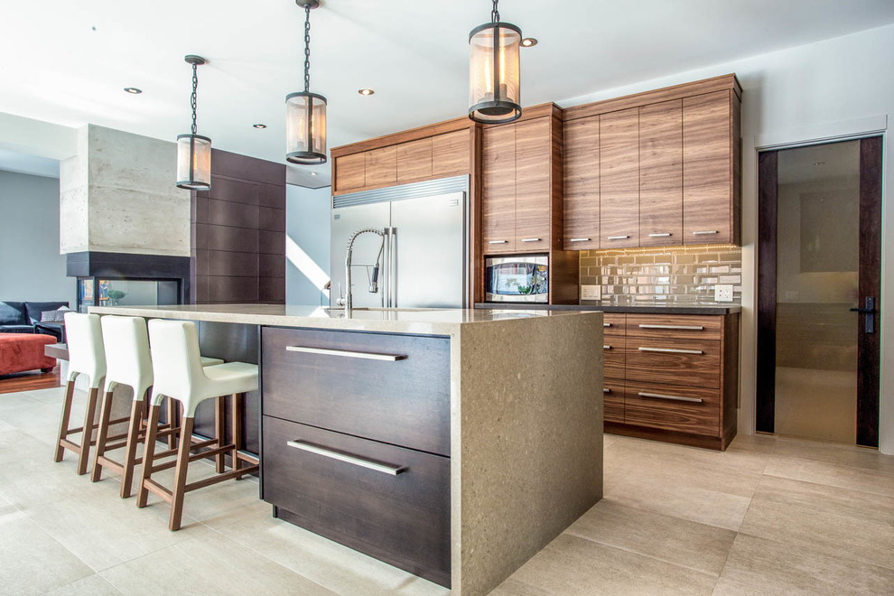 Photo of a contemporary eat-in kitchen in Toronto with an undermount sink, flat-panel cabinets, medium wood cabinets, stainless steel appliances and subway tile splashback.