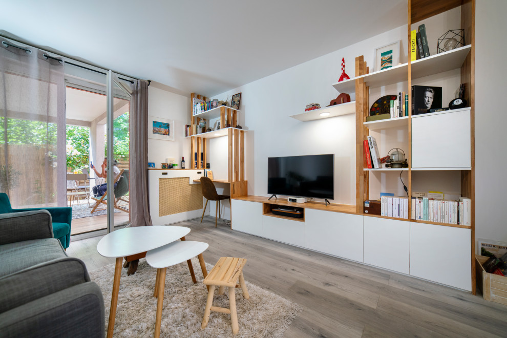 Foto på ett mellanstort minimalistiskt allrum med öppen planlösning, med ett bibliotek, vita väggar, ljust trägolv, en fristående TV och beiget golv
