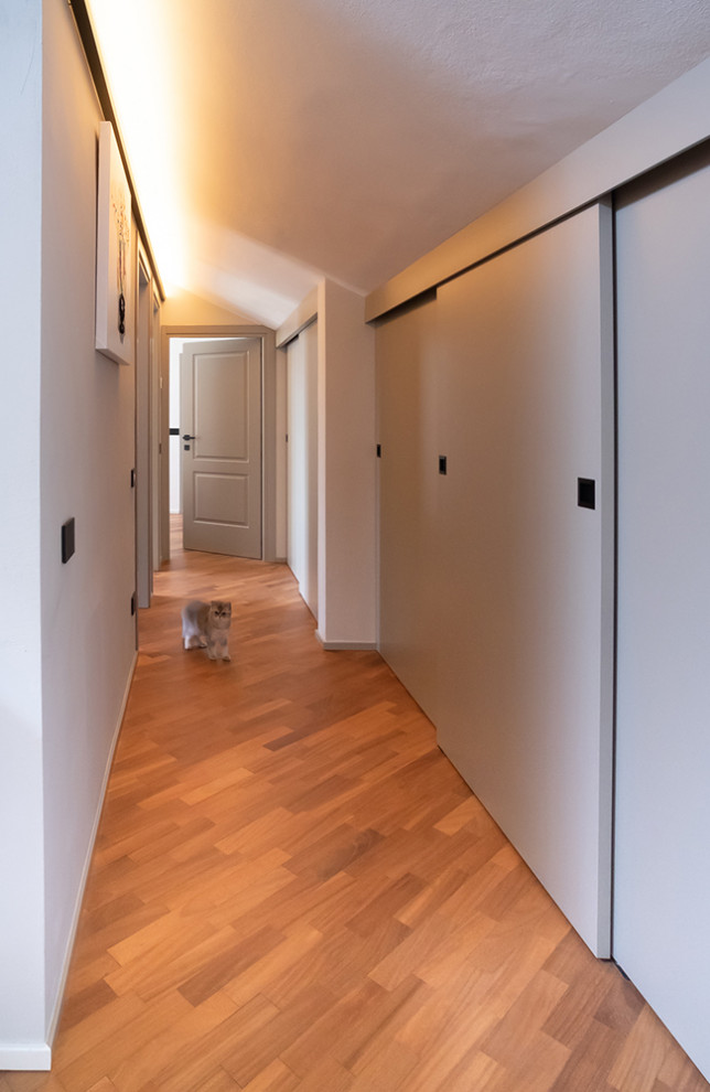 Пример оригинального дизайна: коридор среднего размера в современном стиле с темным паркетным полом и панелями на стенах