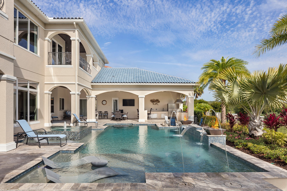 Expansive mediterranean backyard rectangular pool in Orlando with a water feature.