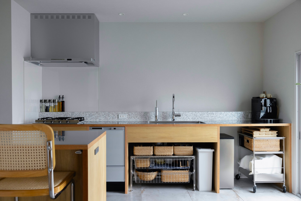 Photo of a small country single-wall open plan kitchen in Other with an undermount sink, open cabinets, light wood cabinets, stainless steel benchtops, grey splashback, terra-cotta splashback, coloured appliances, cement tiles, with island, green floor, brown benchtop and wallpaper.