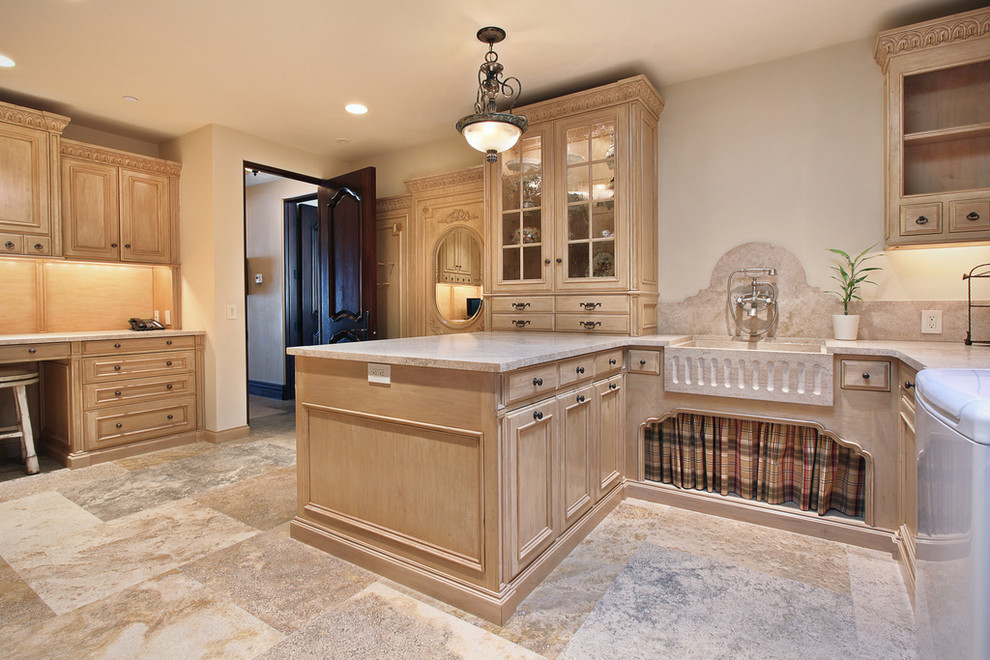 This is an example of a large mediterranean utility room in Orange County with light wood cabinets, beige walls, a side-by-side washer and dryer, recessed-panel cabinets and a farmhouse sink.