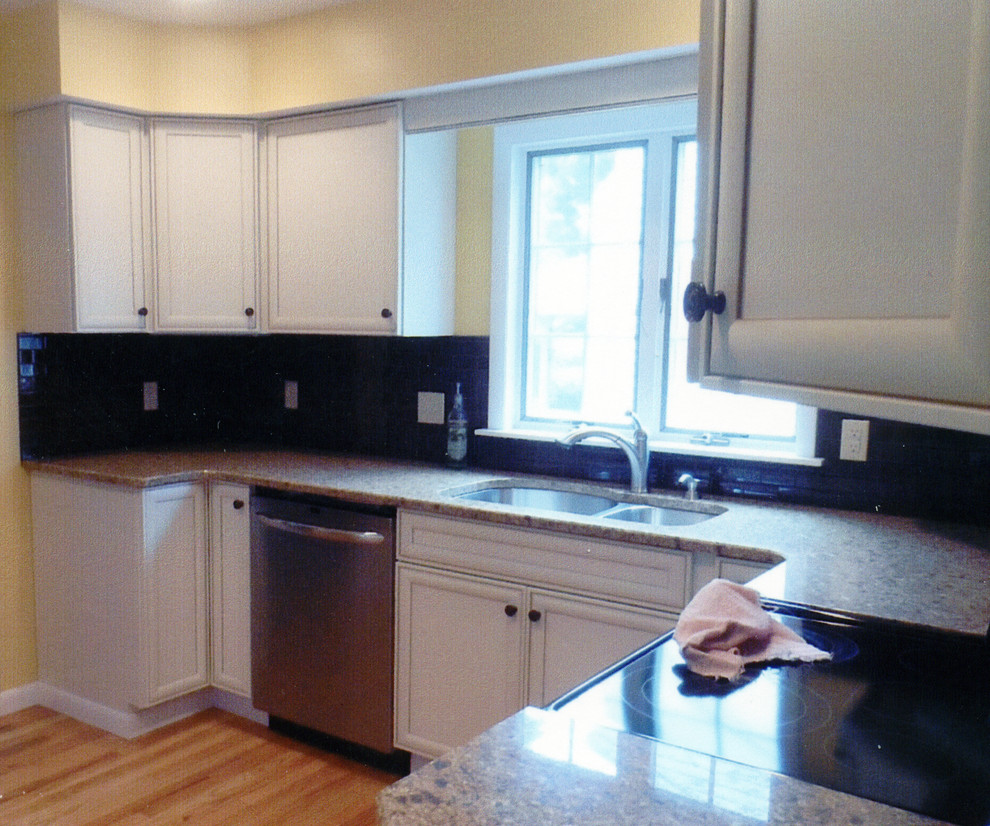 Kitchen pantry - mid-sized transitional l-shaped laminate floor and yellow floor kitchen pantry idea with an undermount sink, recessed-panel cabinets, white cabinets, granite countertops, brown backsplash, ceramic backsplash, stainless steel appliances, no island and beige countertops