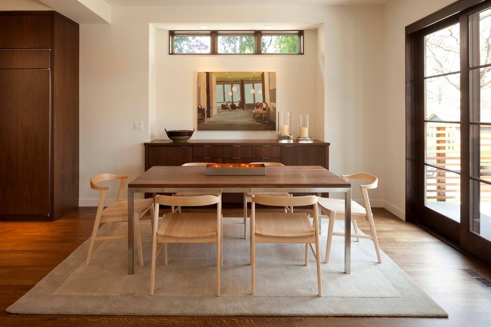 This is an example of a contemporary dining room in Minneapolis with beige walls and medium hardwood floors.