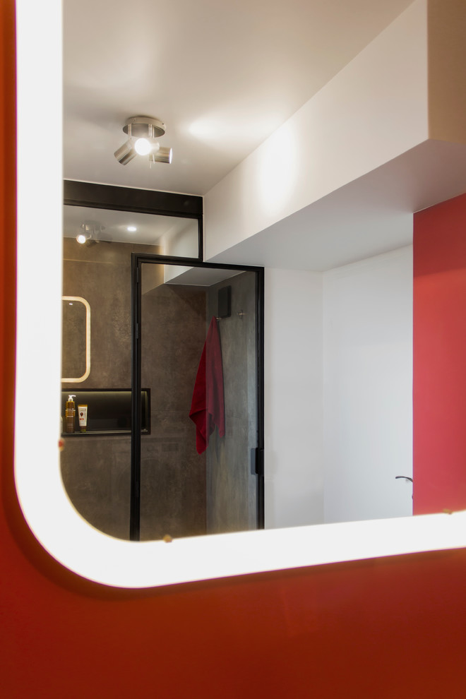 Photo of a mid-sized modern master bathroom in Paris with flat-panel cabinets, brown cabinets, a curbless shower, a wall-mount toilet, brown tile, ceramic tile, red walls, ceramic floors, a vessel sink and solid surface benchtops.