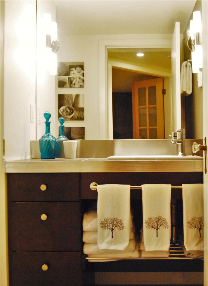 Réalisation d'une salle de bain design en bois foncé de taille moyenne avec sol en béton ciré, un plan de toilette en carrelage, un plan de toilette noir, meuble simple vasque, un placard à porte plane et meuble-lavabo encastré.