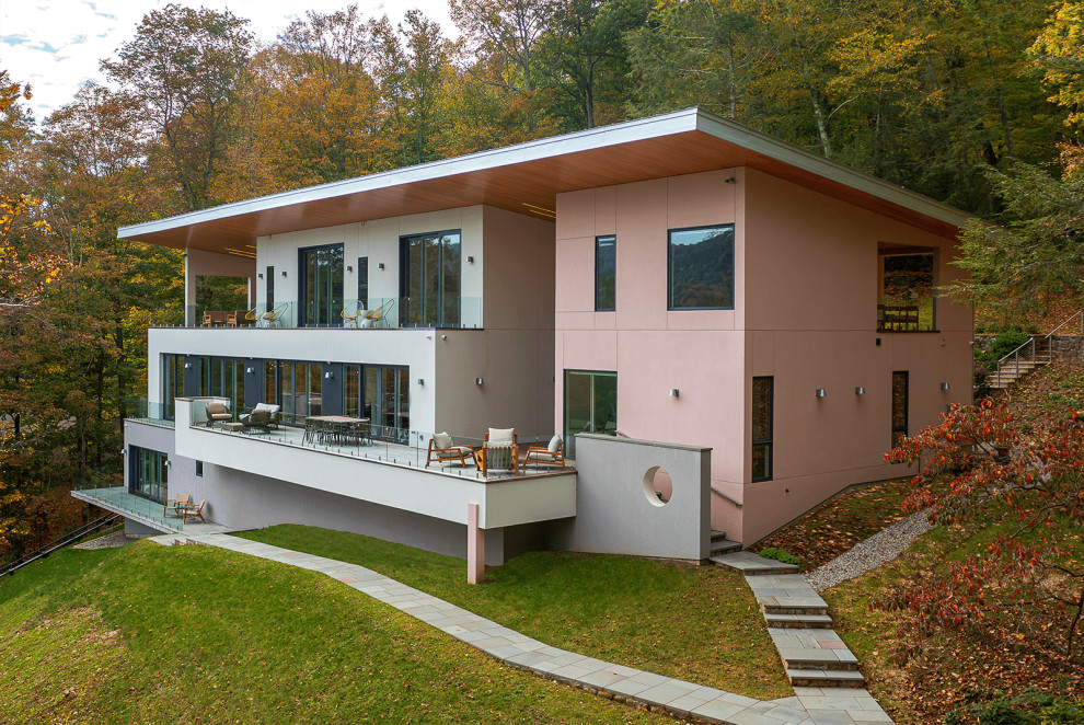 Foto della villa bianca moderna a due piani di medie dimensioni con tetto piano, copertura in metallo o lamiera e tetto bianco