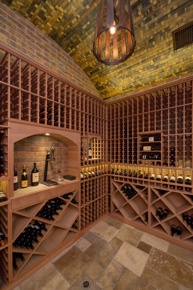 This is an example of a large traditional wine cellar in Phoenix with travertine floors and diamond bins.