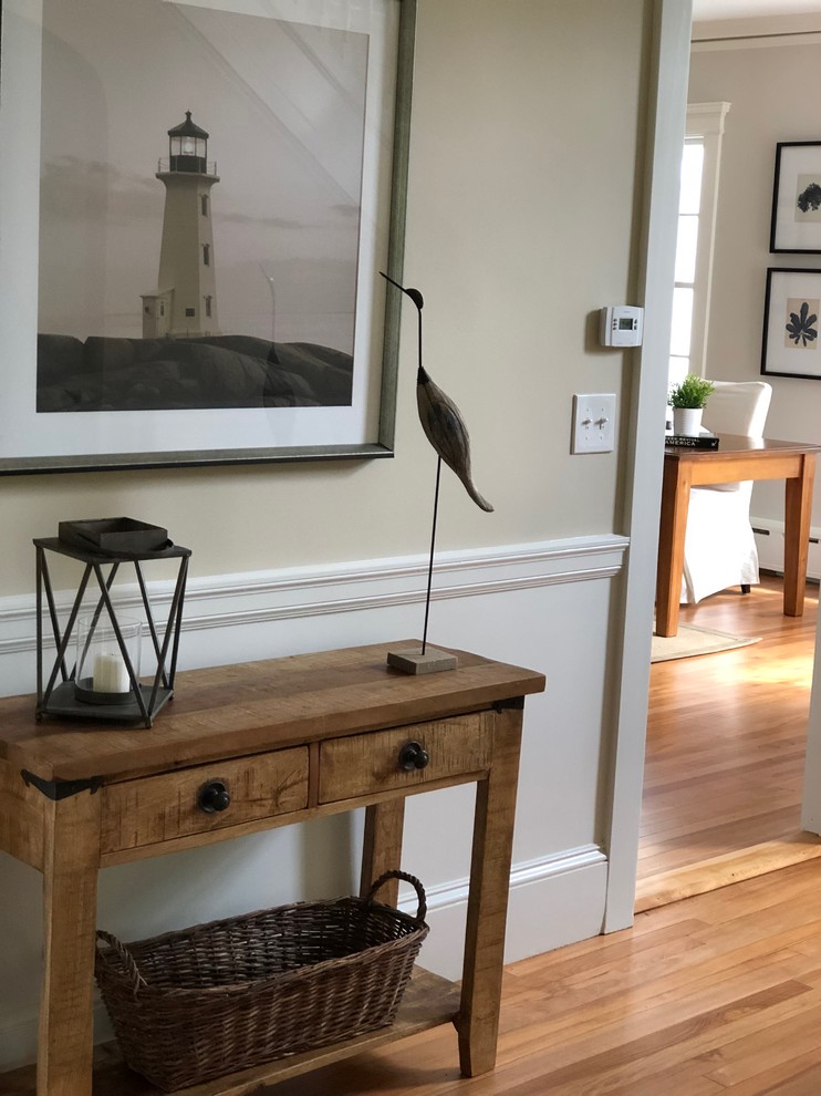 Photo of a large beach style foyer in Boston with beige walls, medium hardwood floors and brown floor.