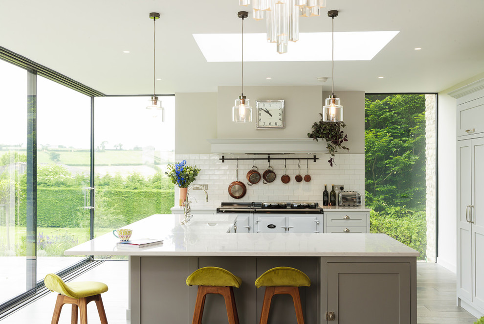 Inspiration for a large transitional kitchen in Other with shaker cabinets, solid surface benchtops, white splashback, subway tile splashback, with island, grey cabinets and white appliances.