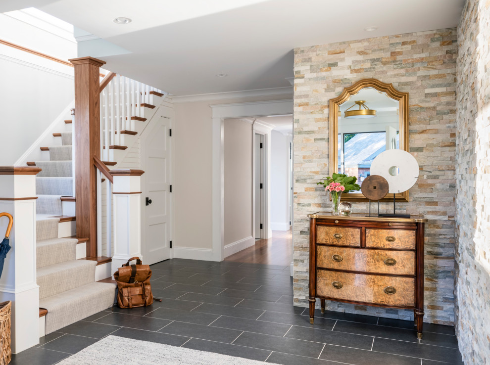 This is an example of a beach style foyer in Boston with beige walls and grey floor.