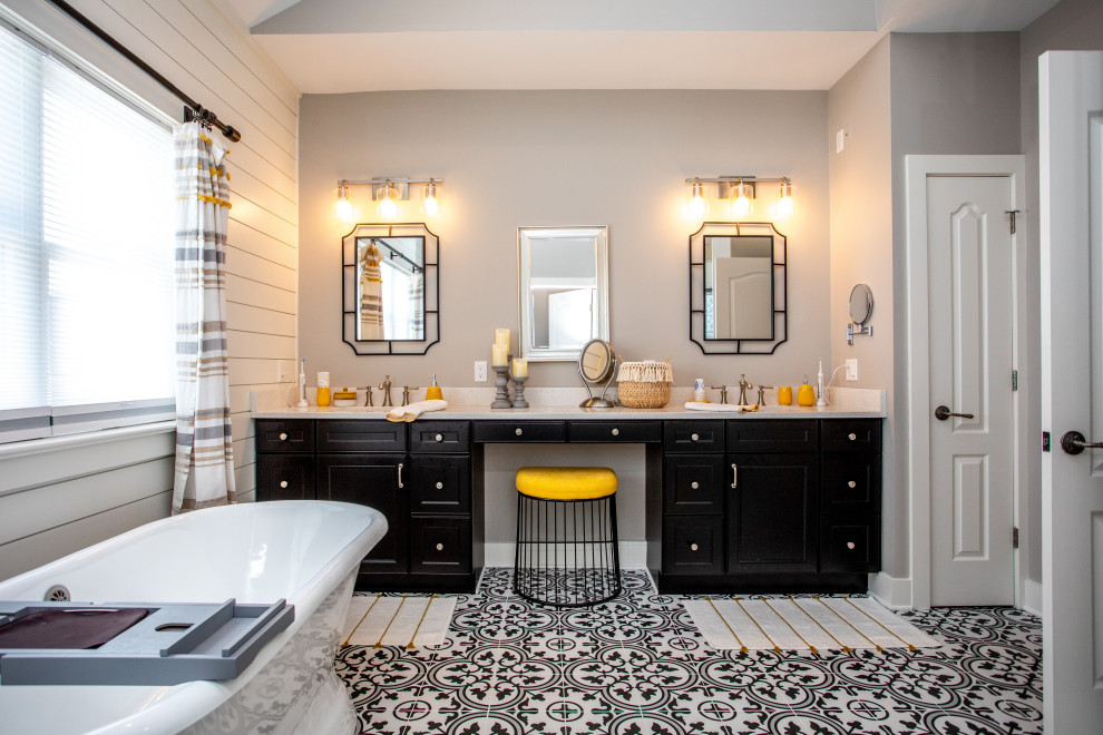 Large transitional master bathroom in New York with black cabinets, a freestanding tub, an alcove shower, a one-piece toilet, black and white tile, cement tile, grey walls, ceramic floors, a drop-in sink, granite benchtops, black floor, a hinged shower door, beige benchtops, an enclosed toilet, a double vanity, a built-in vanity, vaulted, planked wall panelling and shaker cabinets.