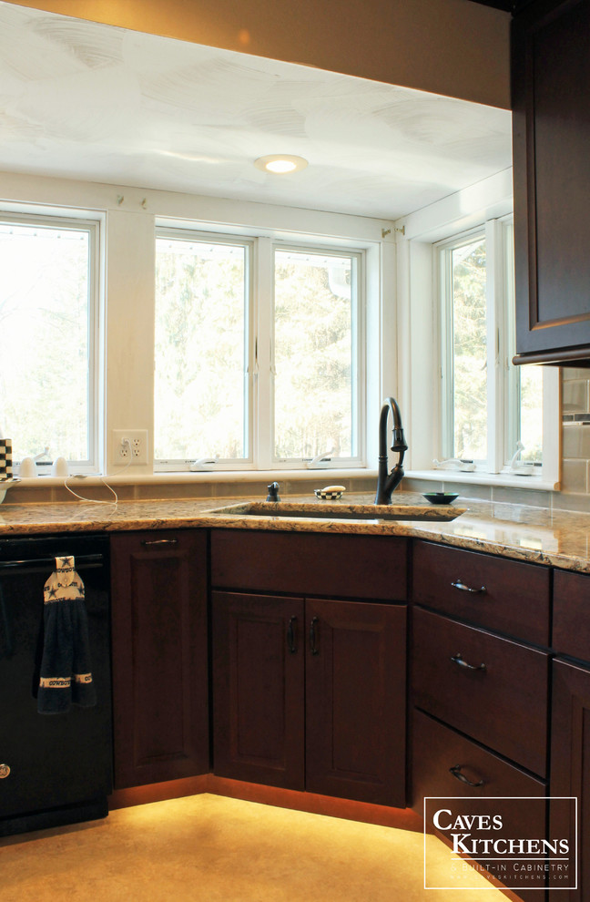 Mid-sized transitional l-shaped vinyl floor eat-in kitchen photo with an undermount sink, flat-panel cabinets, dark wood cabinets, quartz countertops, beige backsplash, ceramic backsplash, black appliances and an island