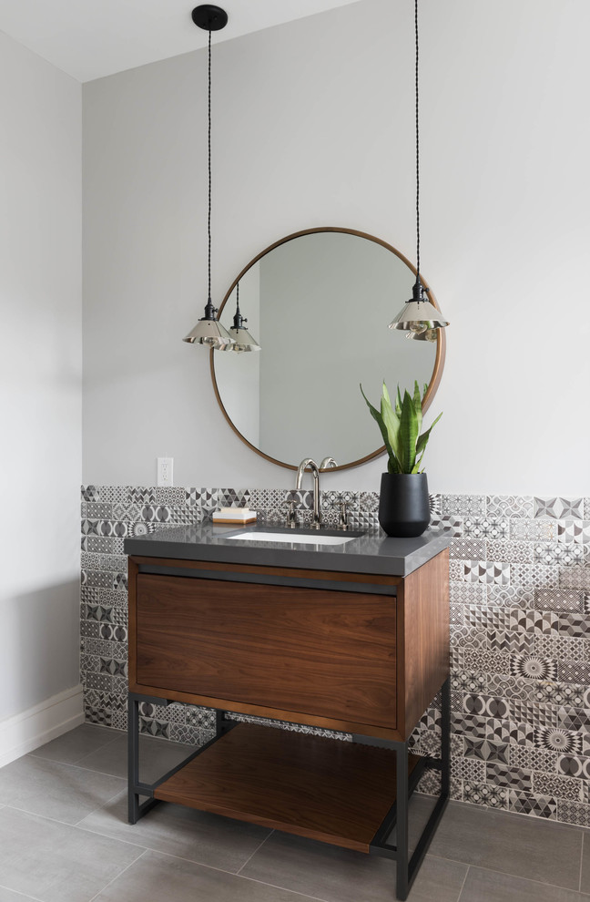 Photo of a contemporary bathroom in Toronto with dark wood cabinets, black and white tile, white walls, an undermount sink and flat-panel cabinets.