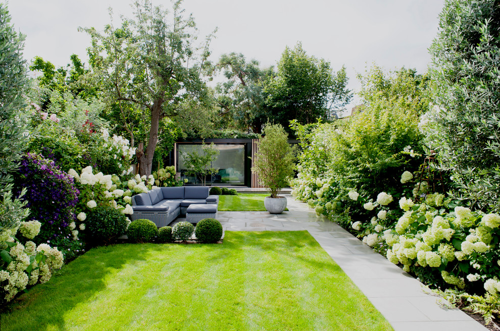 Ispirazione per un grande giardino contemporaneo esposto in pieno sole dietro casa in estate con pavimentazioni in pietra naturale e recinzione in legno