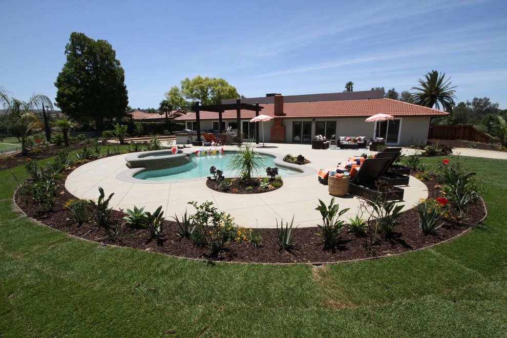 Hot tub - mid-sized transitional backyard concrete paver and custom-shaped lap hot tub idea in Orange County