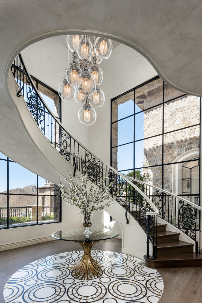 This is an example of a large curved staircase in Phoenix with metal railing.