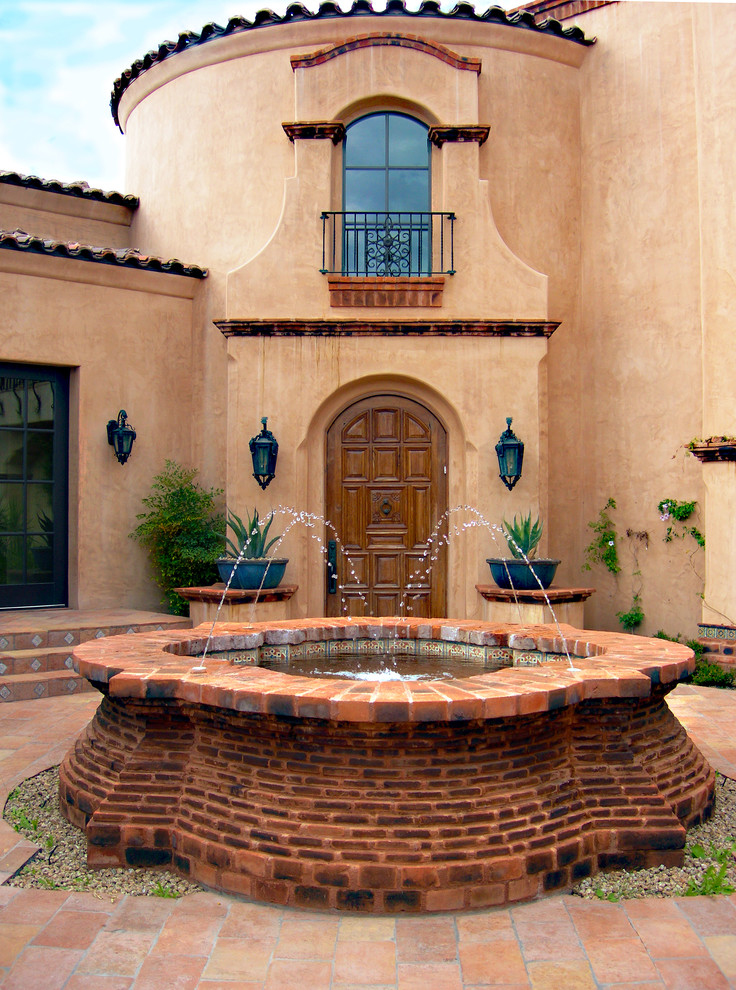Design ideas for a large courtyard partial sun formal garden in Miami with a water feature and brick pavers.