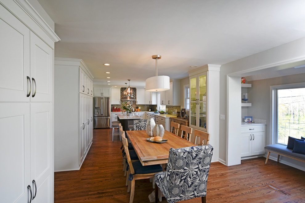 Transitional l-shaped medium tone wood floor eat-in kitchen photo in Orange County with a double-bowl sink, shaker cabinets, white cabinets, marble countertops, gray backsplash, glass tile backsplash, stainless steel appliances and an island