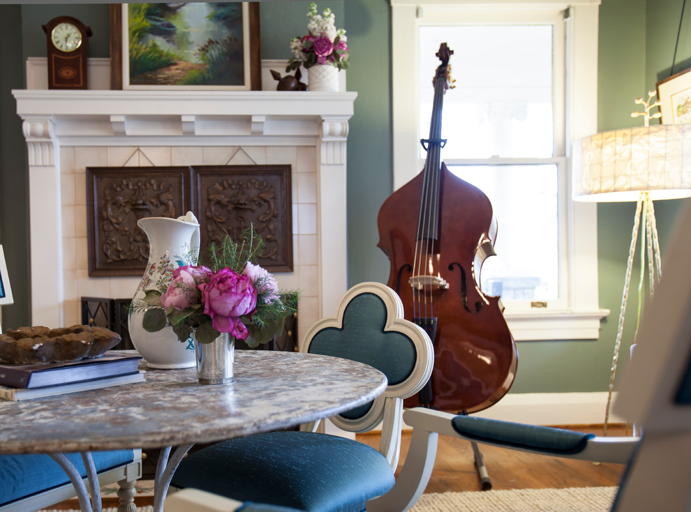 Photo of a mid-sized traditional open plan dining in Atlanta with green walls, medium hardwood floors, a standard fireplace and a concrete fireplace surround.