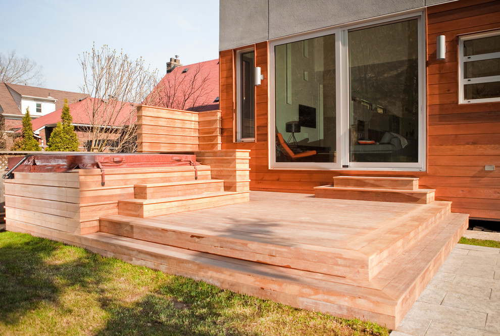 Deck - large modern backyard deck idea in Toronto