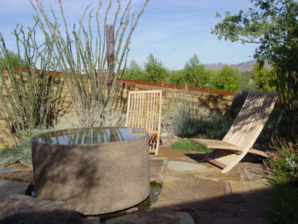 Photo of a large modern backyard patio in Phoenix with natural stone pavers, no cover and a water feature.