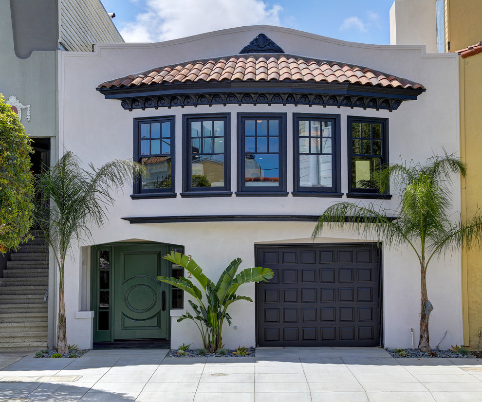 This is an example of a mid-sized tropical three-storey stucco white house exterior in Other with a tile roof.