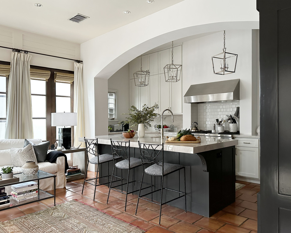 Example of a mid-sized tuscan terra-cotta tile open concept kitchen design in Austin with stainless steel appliances and an island