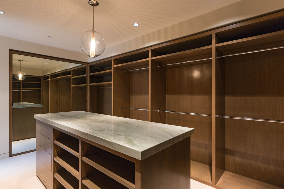 Large contemporary gender-neutral walk-in wardrobe in Los Angeles with medium wood cabinets, porcelain floors and open cabinets.