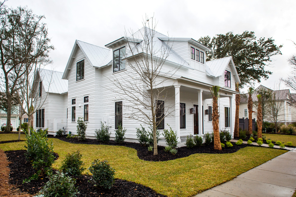 Photo of a large modern two-storey white exterior in Charleston with concrete fiberboard siding and a hip roof.