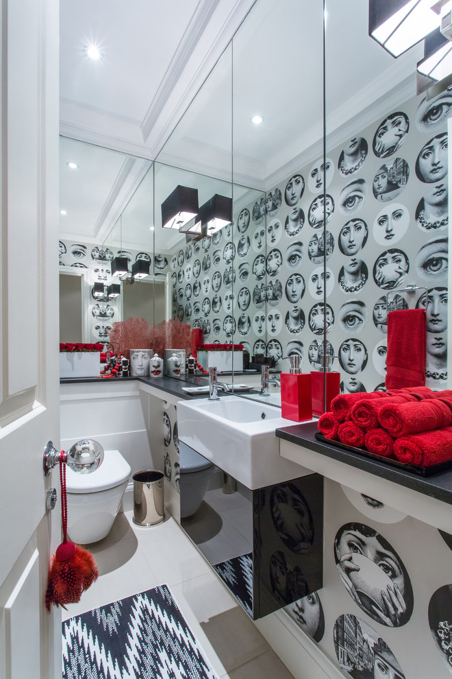 This is an example of a contemporary powder room in London with flat-panel cabinets, black cabinets, a wall-mount toilet, grey walls and a wall-mount sink.