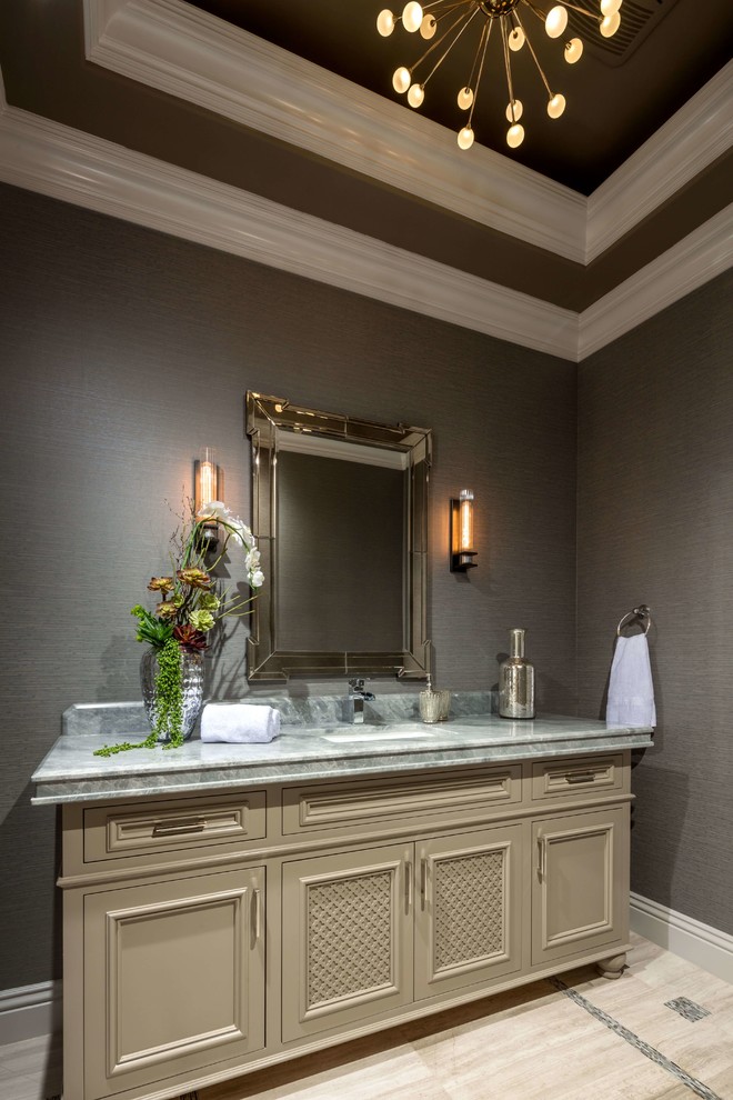 This is an example of a mid-sized beach style bathroom in Los Angeles with raised-panel cabinets, beige cabinets, grey walls, an undermount sink, multi-coloured floor and grey benchtops.
