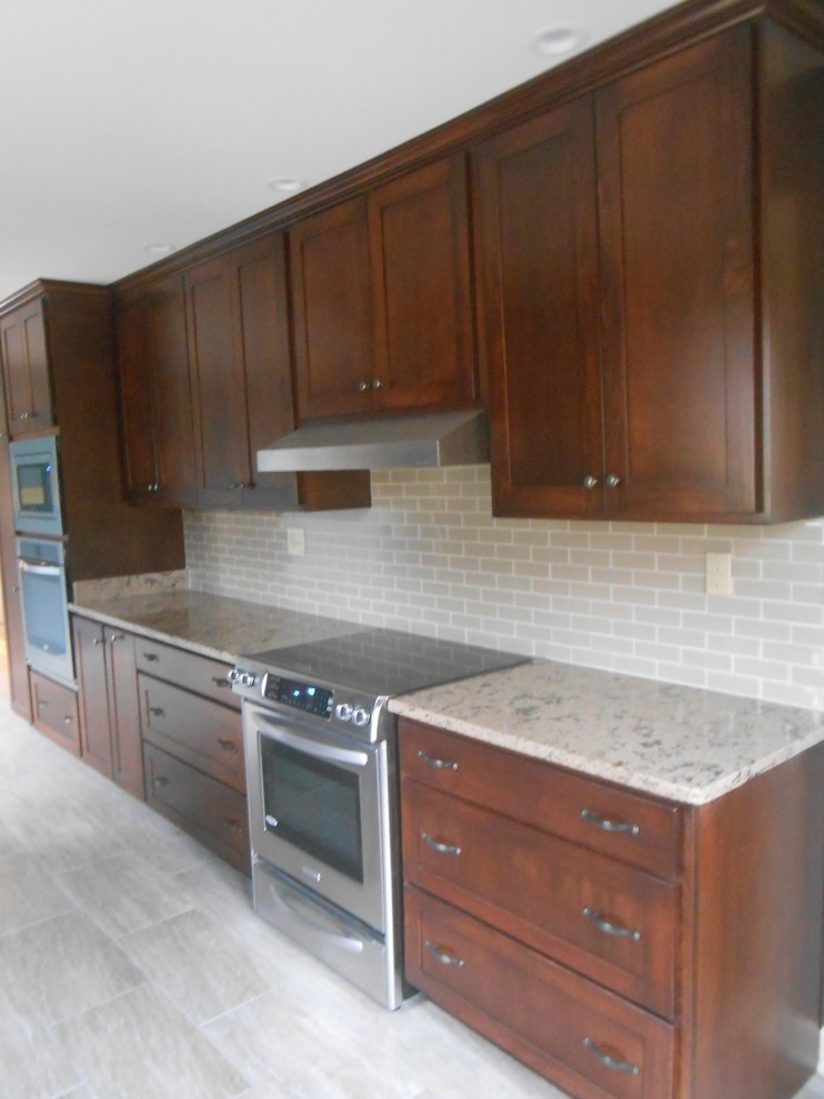 Example of a mid-sized transitional galley porcelain tile eat-in kitchen design with an undermount sink, shaker cabinets, dark wood cabinets, quartz countertops, beige backsplash, glass sheet backsplash, stainless steel appliances, blue walls and no island