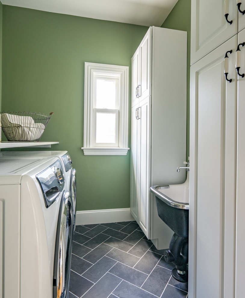 Design ideas for a transitional galley dedicated laundry room in Boston with raised-panel cabinets, white cabinets, slate floors and grey floor.