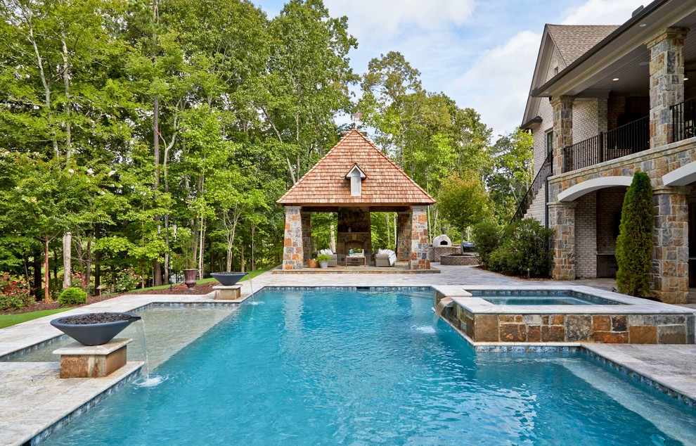 Large mountain style backyard stone and rectangular infinity hot tub photo in Atlanta