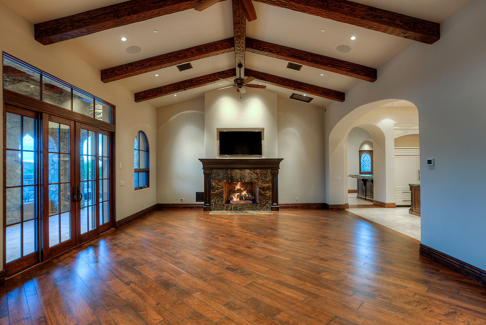 Design ideas for a large transitional formal open concept living room in Phoenix with white walls, medium hardwood floors, a standard fireplace, a stone fireplace surround and a wall-mounted tv.