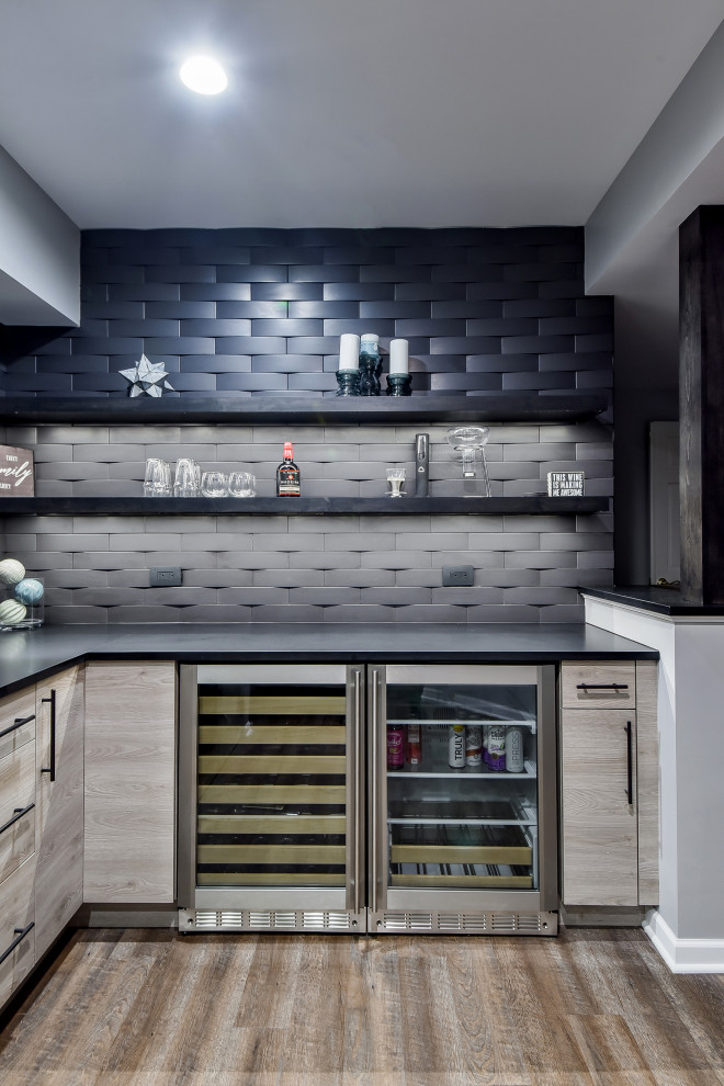 Inspiration for a contemporary l-shaped home bar in Nashville with flat-panel cabinets, brown cabinets, black splashback, brown floor and black benchtop.