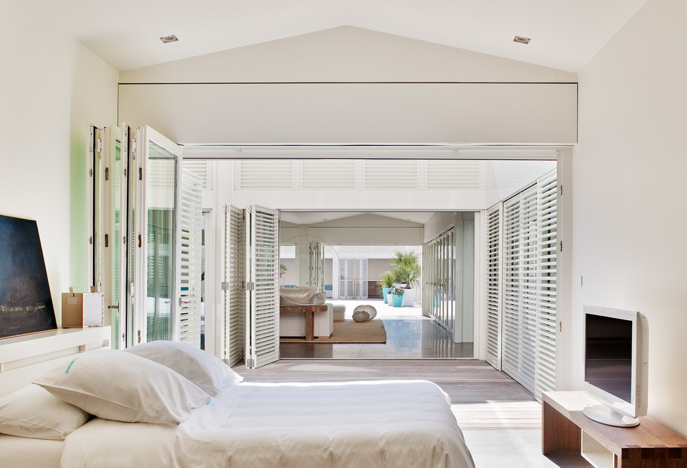 Mid-sized beach style master bedroom in Marseille with white walls and light hardwood floors.