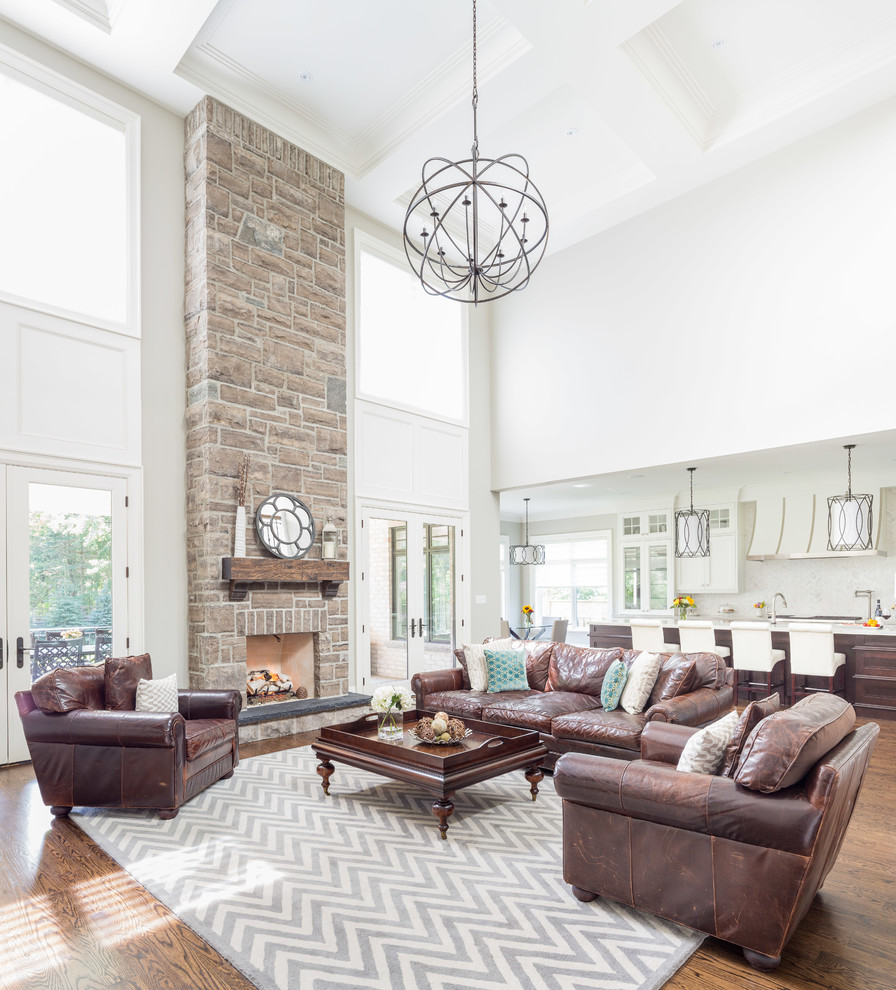 Transitional open concept living room in Toronto with white walls, dark hardwood floors, a standard fireplace and a stone fireplace surround.