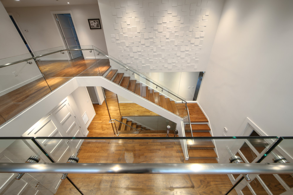 Inspiration for a large modern wood l-shaped staircase in New York with glass risers and glass railing.