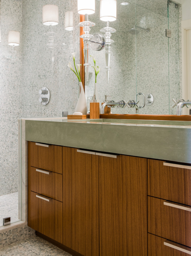 Photo of a mid-sized contemporary 3/4 bathroom in Boston with flat-panel cabinets, medium wood cabinets, concrete benchtops, an alcove shower, gray tile, stone tile, a trough sink and grey benchtops.