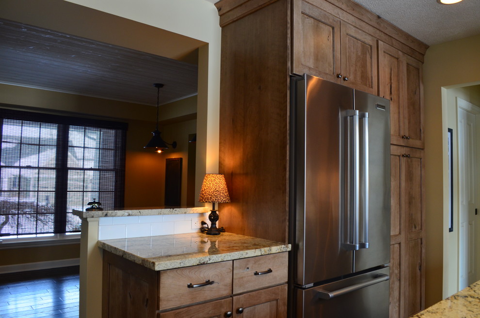 Inspiration for a rustic l-shaped dark wood floor eat-in kitchen remodel with an undermount sink, shaker cabinets, medium tone wood cabinets, laminate countertops, black backsplash, subway tile backsplash, stainless steel appliances and two islands
