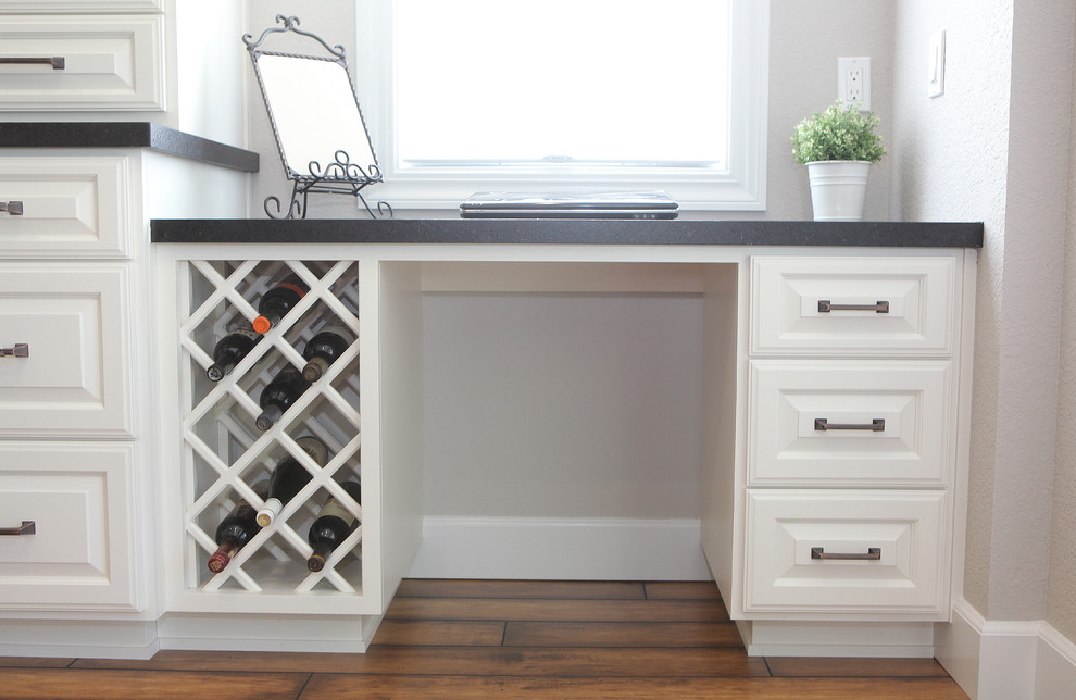 Eat-in kitchen - transitional eat-in kitchen idea in Sacramento with white cabinets, solid surface countertops and stainless steel appliances