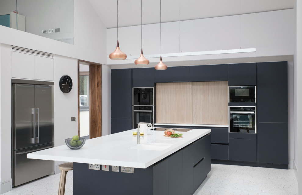 Inspiration for a large modern single-wall kitchen in Other with an integrated sink, glass-front cabinets, blue cabinets, solid surface benchtops, black appliances, concrete floors, with island and grey floor.