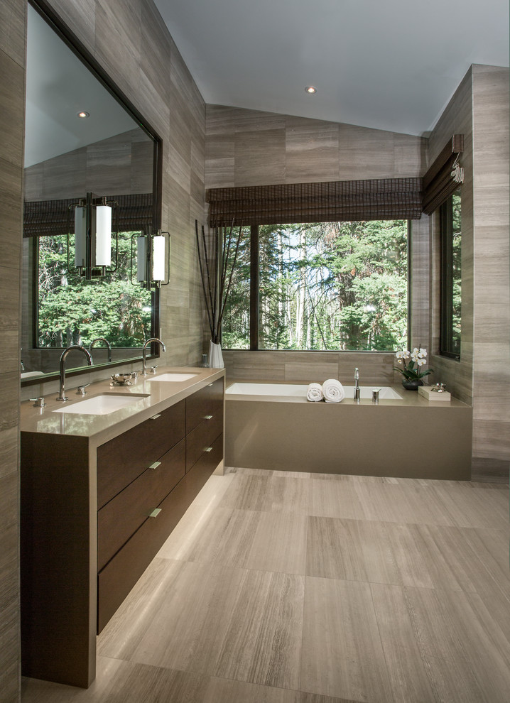 Photo of a mid-sized contemporary master bathroom in Salt Lake City with an undermount sink, flat-panel cabinets, dark wood cabinets, an undermount tub, gray tile, quartzite benchtops, stone tile, grey walls and limestone floors.