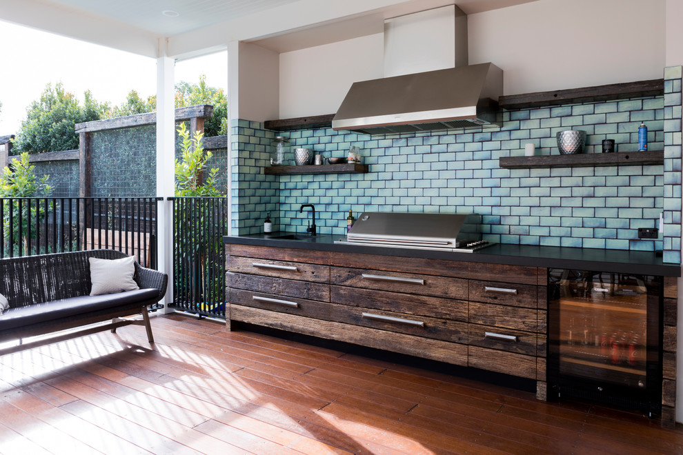 This is an example of a contemporary deck in Melbourne with an outdoor kitchen and a roof extension.