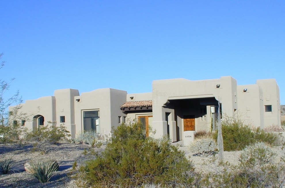 Photo of a mid-sized one-storey adobe beige exterior in Phoenix with a flat roof.