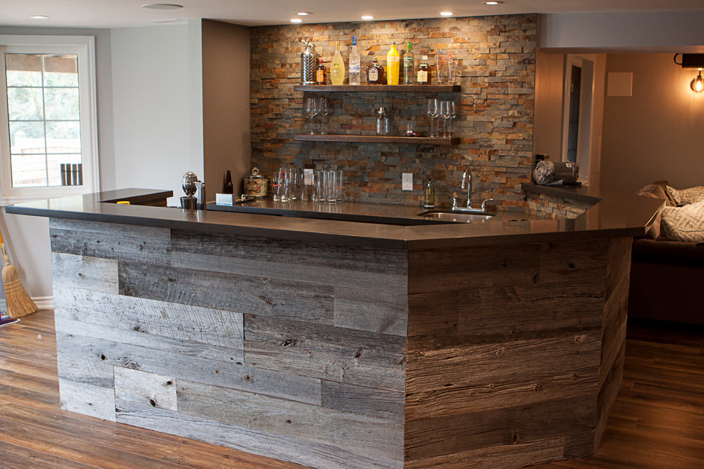 Photo of a large country home bar in Toronto with laminate floors and brown floor.